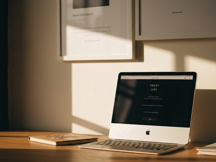 펼쳐진 계약서와 볼펜, 인감 도장이 놓인 나무 책상