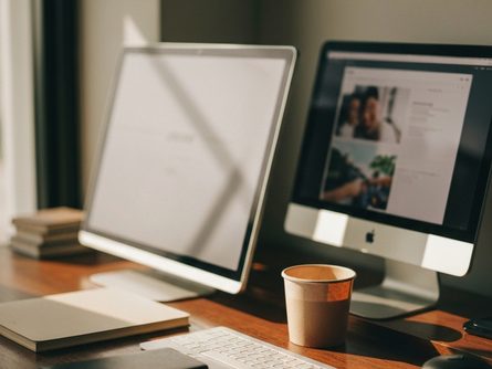 햇살 드는 거실 창가에 놓인 건축 모형과 설계 도면, 펜과 계산기 클로즈업